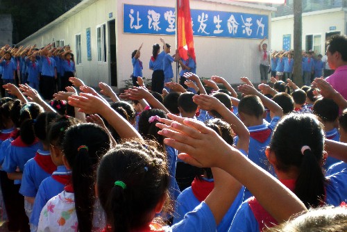9月1日,四川省雅安市雨城区兴贤小学学生参加开学典礼。当日,四川地震中被毁坏的部分中、小学,在临时板房校区举行了新学期开学典礼。新华社记者 陈燮 摄
