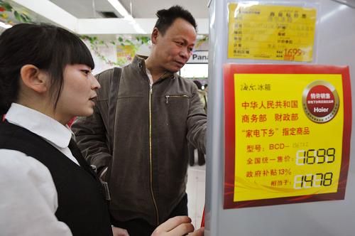 3月1日,家住米泉市羊毛工镇的农民刘小成(右)在咨询家电下乡产品。 新华社记者 赵戈 摄