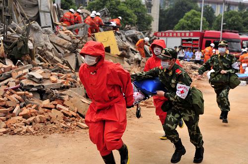 5月11日,救援人员在“地震现场”抢救伤员。当日,在成都市体育中心被还原的房屋坍塌废墟上,多部门联动模拟“5·12”抗震救灾救援场景的应急演练拉开帷幕。在接到“救援任务”后,公安局刑警支队、消防支队、特警支队和武警支队以及120急救中心等迅速赶到现场,警犬搜救,警戒照明组、多功能救援车纷纷派上用场……经过紧张的“搜救”,“伤者”被成功救出送往医院抢救。据悉,参加此次应急演练的都是“5·12”地震发生后当天第一时间赶往灾区救援的人员。 新华社记者 郝同前 摄