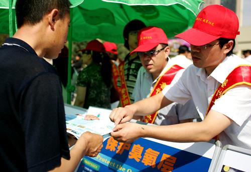 6月5日,在内蒙古呼和浩特市,志愿者向市民发放环保知识宣传单。新华社发(郑焕松摄)