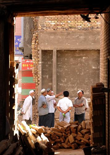 月3日,新疆喀什市老城区的维吾尔族居民在改造工地上观看工程进度。 新华社记者 沈桥 摄