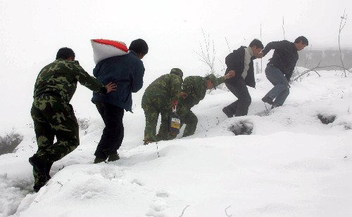 2月22日,云南省彝良县武装部领导带着粮油等生活用品深入重灾区彝良县龙潭村慰问灾民中的困难户,龙潭村至今仍被半尺多厚的积雪所覆盖。这个村虽然被冰雪“封锁”了一个多月,但在多方努力下,群众吃住没有发生大的困难。 新华社记者王建民摄