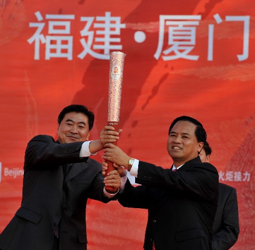 5月12日,在庆典仪式上,北京奥组委官员刘宝杰(左)向厦门市市长刘赐贵赠送纪念火炬。当日,北京奥运会圣火在福建省厦门市传递。 新华社记者张国俊摄