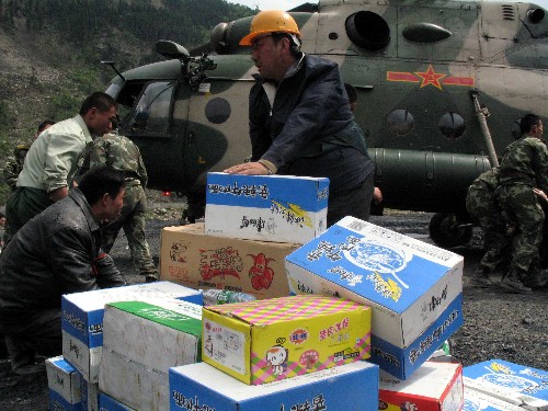 5月14日,救援人员在四川省汶川县映秀镇灾区搬运通过直升机空运的救灾物资。 目前,各救援队伍正动用一切手段陆续进入地震重灾区汶川。 新华社记者李彤摄