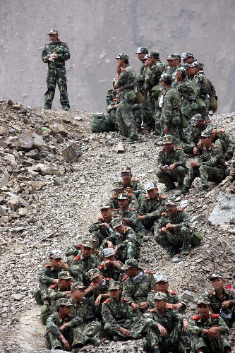 5月31日,水电官兵们等待撤离。 当日,第一批武警水电官兵已乘直升机开始从唐家山堰塞湖撤出,31日预计撤出350名左右官兵。据唐家山堰塞湖抢险指挥部介绍,经过紧张施工,截至31日7时,已累计完成开挖土石方12.35万方,大坝进口高程降至741米,出口高程降至739米。 新华社记者李刚摄