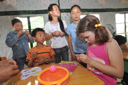 5月31日,天河海军小学的学生在教室内与来自加拿大的小朋友珍妮一起做手工。 “六一”儿童节来临之际,四川省绵竹市东北镇天河海军小学的学生以积极乐观的态度迎接自己的节日。 新华社记者 郝同前摄