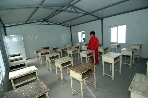 陕西灾区有了高考“活动考场” 6月4日,工人在活动板房内安置书桌。 经有关方面人员连续几天的奋战,陕西汉中市地震灾区宁强县、略阳县已搭建完成了112间防震活动板房,两县3045名学生将在这些“活动考场”中如期参加高考。 新华社记者丁海涛摄
