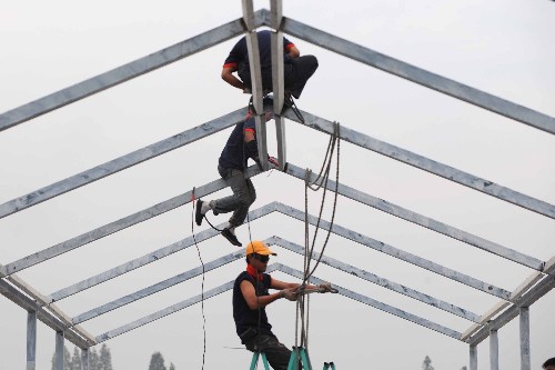 6月4日,在都江堰市聚源镇的河北省唐山市援建安置房建设工地,约1800多间安置房正在加紧搭建。 据悉,截至3日,四川灾区过渡安置房已安装19900套、正安装12800套、待安装61300套,生产地已发运43300套、待发运52300套。 新华社记者 武巍 摄