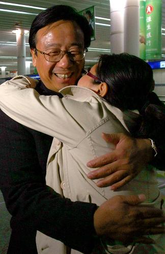 11月30日,旅客周缇(右)和来机场迎接她的父亲热情拥抱。当日2时15分,中国东方航空公司的MU548航班接回246名滞留在泰国的中国旅客,以及26名滞留的机组人员,平安抵达上海。 新华社记者凡军摄