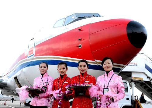 12月27日,两名空乘人员(中间两名)和迎宾人员正在等待游客到来。