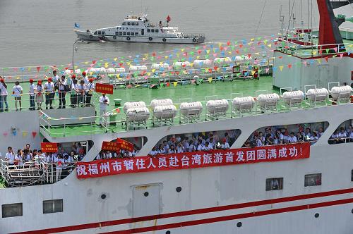 5月30日,游客在客轮上向送行亲友致意。 当日,福州市暂住人员赴台湾旅游首发团的515名游客分别搭乘“合富轮”和“金龙号”客轮从福州马尾港启程,前往台湾本岛及马祖地区旅游,实现了在榕暂住人员经福州口岸赴台湾地区(含金门、马祖、澎湖)旅游的新突破。至此,福州成为继厦门之后第二个经公安部批准开展暂住人员赴台湾旅游的试点城市。 新华社记者 张国俊 摄