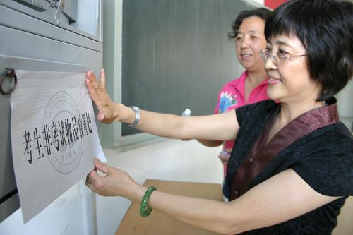 6月5日,两名老师在天津某高考考点张贴“考生非考试物品放置处”标识。 高考在即,全国各考点学校陆续完成各项准备工作,为考生创造良好的考试环境。 新华社发(李想 摄)