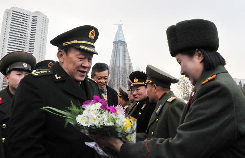 11月22日,中国国务委员兼国防部长梁光烈(左)在平壤祖国解放战争胜利纪念塔广场接受献花。应朝鲜人民武装力量部的邀请,梁光烈当日抵达平壤,开始对朝鲜进行为期5天的访问。 新华社记者姚西蒙摄