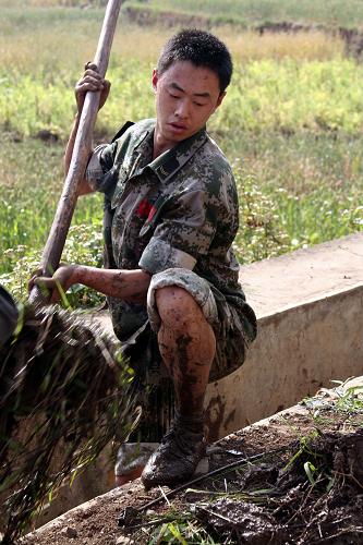 成都军区某红军师官兵援黔抗旱保民生 4月4日,在盘县板桥镇金家庄村,解放军战士清理疏通可灌溉3个村400亩农田的灌渠。 成都军区某红军师炮兵团某连在贵州省盘县旱情严重的板桥镇刚刚驻扎下来,就立即投入到抗旱救灾中,为饮水困难群众送水、抢修水利设施、帮助群众春耕抢种。 新华社发(黄蜀锦 摄)
