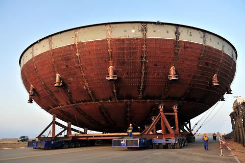 海阳核电一号核岛CV底封头吊装成功 4月9日,大型平板运输车正将CV底封头运抵吊装现场。CV底封头由64张弧形钢板组焊而成,总重量近700吨。 当日,建设中的山东海阳核电站项目一号核岛重大节点工程CV(钢制安全壳)底封头成功实现整体吊装。CV是一个内径39.6米、高65.6米的钢制压力容器,由中间的圆柱形筒体和上下两个椭圆型封头组成。CV是防止放射性物质外泄的第三道安全屏障,在事故工况下,钢制安全壳容器自身提供传热表面将热量从安全壳内导出排入大气,以有效冷却安全壳并使压力迅速下降。 新华社记者 李紫恒 摄