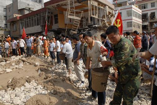 8月9日,舟曲县乡镇干部群众和民兵在重灾区三眼峪抢险救灾。 当日,舟曲县全面开展抢险救灾工作,力争把损失降到最低。截至9日11时,正在舟曲特大山洪地质灾害现场救援的公安消防部队官兵已经救出被困群众77人。 新华社发(后俊 摄)