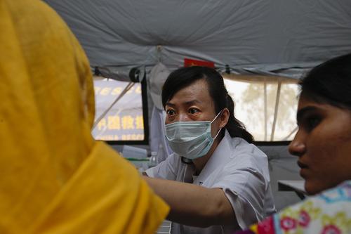 9月16日,在巴基斯坦南部受洪灾最严重的特达地区马克里镇,来自武警总医院消化内科的医生黎君为病人诊治。 正在巴基斯坦进行医疗救助的中国国际救援队考虑到该国的风俗,特意在流动医院内建立了“女士门诊”,专为妇女、儿童接诊。三名来自武警总医院的女医生在志愿者翻译的帮助下耐心问诊,为众多当地妇女、儿童患者诊治疾病。 新华社记者 周磊 摄