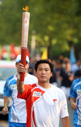 5月17日,畲族火炬手、小学教师雷旭雄在进行传递。当日,北京奥运会圣火在浙江绍兴传递。 新华社记者邢广利摄