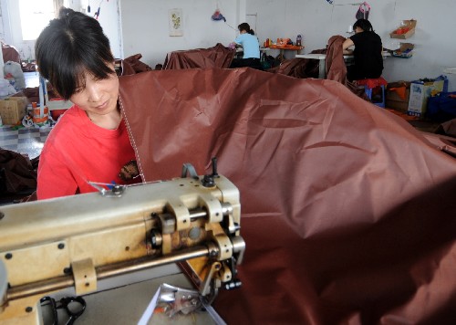 5月21日,杭州余杭区的一家生产帐篷的企业员工正在加紧生产救灾帐篷。汶川大地震后,浙江生产帐篷的企业加班加点生产救灾帐篷,紧急支援四川灾区。新华社记者 王定昶 摄