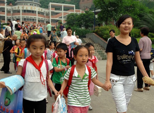 5月21日,在重庆市九龙坡区天宝实验学校,从四川地震灾区德阳市第一小学转来的新同学黄婷玉(前中)和天宝实验学校师生们步出学校。 重庆市教委当日发布的最新统计显示,重庆接收的四川地震灾区中小学学生已超过600名。目前,重庆市教委已经为四川地震灾区学生开辟了“绿色通道”,各大中小学校不但对地震灾区的学生实行免费入学就读,而且对家庭困难的灾区中小学生还免费提供学习用品,补助生活费用。同时,各接收学校还积极通过班主任或心理教师做好灾区学生的心理疏导工作,通过班集体的力量和老师、同学们的关爱,消除灾区学生的心理创伤。 新华社记者刘潺摄