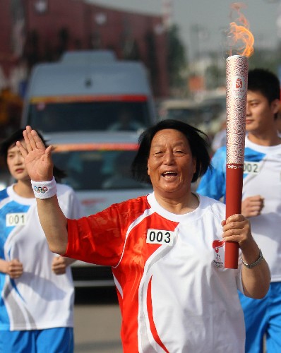 6月26日,奥运火炬手申纪兰手持火炬传递。当日,北京奥运圣火在山西太原传递。 新华社记者邢广利摄