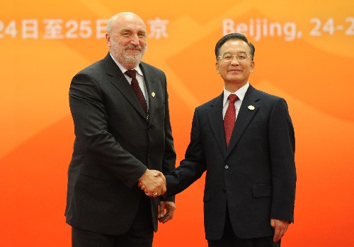 10月24日,中国国务院总理温家宝在北京人民大会堂北大厅迎候前来出席第七届亚欧首脑会议的拉脱维亚总理戈德马尼斯。 新华社记者 马占成 摄