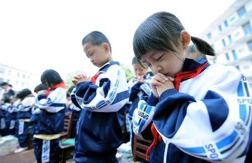5月19日,湖南长沙曙光小学学生在升国旗前为四川地震灾区遇难同胞默哀。当日,湖南长沙数十所小学联动举行“1+1中华强”爱心集结行动,为四川地震灾区的同龄人祈祷祝福,并捐赠书籍27000余本、文体用品16000余件。新华社记者 赵众志 摄