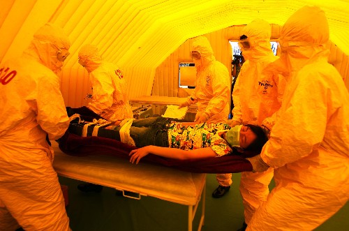 7月15日,北京举行生物恐怖袭击现场处置与医疗救援应急演练,参加演练人员对“重伤员”进行紧急救治。新华社发