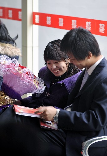 2月14日,一对新人在济南市市中区婚姻登记大厅等候办理结婚手续。新华社记者 朱峥 摄