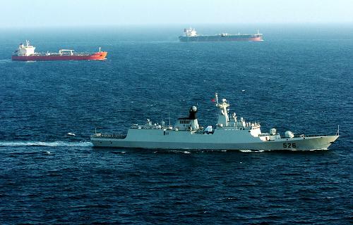 11月13日,在亚丁湾海域,中国海军第四批护航编队的“温州”号导弹护卫舰(前)为商船护航。新华社记者 郭刚 摄