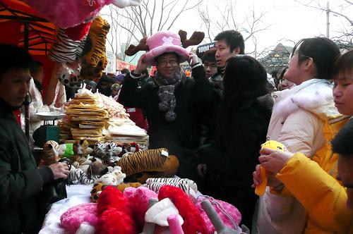 2月18日,游人在北京龙潭庙会挑选玩具帽子。 当日是农历正月初五,俗称“破五”,不少北京市民和游客抓紧春节长假的最后两天逛庙会,大家品小吃、看节目、玩游艺、买商品等,尽情享受节日的轻松与愉悦。 新华社记者赵宇思摄