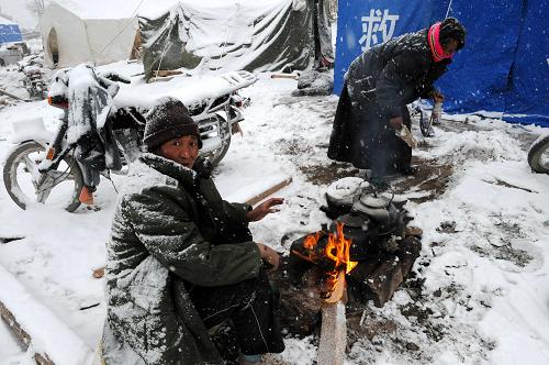 4月22日,在玉树结古镇一处灾民安置点,群众在做早饭。当日,青海玉树地震灾区出现降雪天气。新华社记者 朱祥 摄