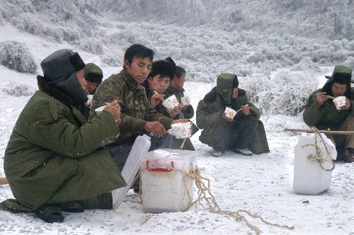 1月31日,抢修一线的电力职工在冰雪中用餐。 新华社记者 杨俊江 摄