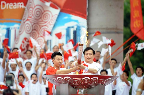 5月10日,奥运火炬手蔡宗泽(前右)与孙淑伟在城市庆典上共同点燃圣火盆。当日,北京奥运圣火传递活动在广东省汕头市举行。 新华社记者刘力航摄