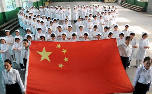 图为:5月20日,三峡大学护理学院即将毕业的600余名学生参加成人宣誓仪式时,沉痛哀悼在地震中遇难的同胞。 新华社发(刘保平摄)