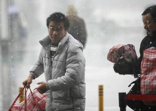 1月6日,一位旅客在武昌火车站准备进站候车。当日,武汉铁路部门发送旅客预计超过10万人次,许多旅客冒着风雪踏上回家的旅途。 新华社记者 郝同前 摄