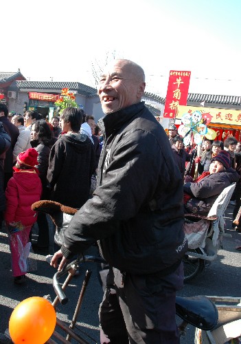 2月9日,北京厂甸庙会上的民俗表演把李大爷逗乐了。李大爷自我介绍1930年出生,家住厂甸5号。新华社记者杨嘉理摄
