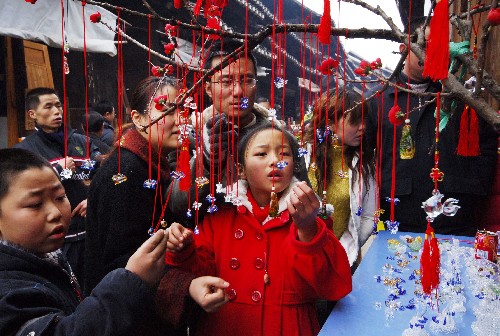 2月9日,游客在挑选鼠形饰品。随着农历鼠年的到来,贵阳花溪区青岩古镇商家推出各种以鼠为主题的手工饰品挂件,受到人们的欢迎。 新华社发(吴东俊 摄)
