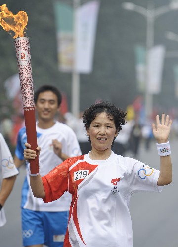 8月7日,火炬手王桂民手持火炬传递。当日,北京奥运圣火在北京市传递。 新华社记者戚恒摄