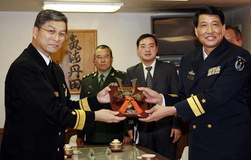 2007年11月28日,中国人民解放军海军军舰出访指挥员、南海舰队副司令员肖新年少将(右一)在参观日本海上自卫队护卫舰“雷”号时,代表“深圳”号导弹驱逐舰接受日本海上自卫队第一护卫舰队司令河村正雄少将赠送的礼物。当天,中国人民解放军海军“深圳”号导弹驱逐舰抵达东京,开始对日本进行为期4天的友好访问。“深圳”舰官兵登上日本海上自卫队护卫舰“雷”号参观,与日舰官兵相互交流,增进了解。 “军舰是流动的国土。”中央军委委员、海军司令员吴胜利在人民海军成立60周年之际接受新华社记者采访时说,作为和平的友好使者,人民海军先后派出33支舰艇编队共40多艘军舰,出访了五大洲的30多个国家。 新华社记者 任正来 摄