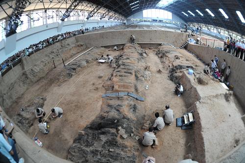 6月13日, 工作人员在一号坑进行发掘工作。 当日,考古人员对被称为“世界第八奇迹”的秦兵马俑一号坑进行发掘,这是其沉寂20多年后迎来的第三次考古发掘。秦兵马俑一号坑是一个东西向的长方形坑,长230米、宽62米,坑东西两端有长廊,南北两侧各有一边廊,中间为九条东西向过洞,过洞之间以夯土墙间隔,估计一号坑内埋有约6000个真人真马大小的陶俑。 新华社记者焦卫平摄