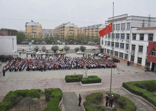 4月21日,在滨城区第四小学举行的“情寄玉树,为灾区祈福”活动中,学生们为玉树地震遇难者默哀。 当日,山东省滨州市滨城区各中小学校举行降半旗悼念活动。 新华社发(李荣新 摄)