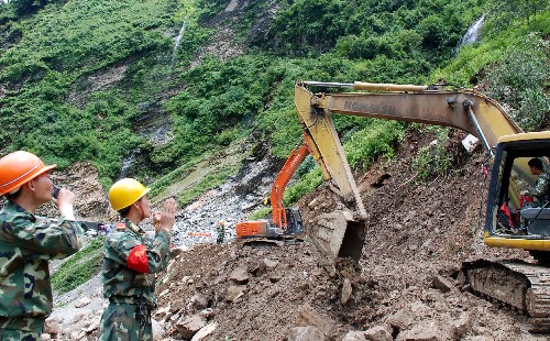 7月28日,武警交通第二支队抢险人员在抢修公路。中尼公路7月25日凌晨发生自1965年建成通车以来最大的一次山体滑坡,此后的几天连续下雨,泥石流频发,造成山体垮塌,面积达300米长、200多米宽,塌方34万立方米。负责抢通任务的武警交通第二支队官兵克服连续强降雨、泥石流不断且作业面狭窄等困难,奋力抢修道路的同时在山腰开辟临时行人通道,确保生活物资的运送。 新华社记者 张泽伟 摄