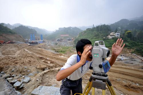 9月10日,建设者在秭归县三峡翻坝高速公路工地进行测量工作。新华社记者 郝同前 摄