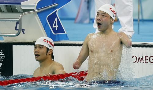 9月15日,中国选手许庆(右)欢呼胜利。他在北京2008年残奥会S6级男子50米自由泳决赛中,以29秒78的成绩打破世界纪录并获得冠军。当日,北京残奥会游泳比赛收官。新华社记者 凡军 摄