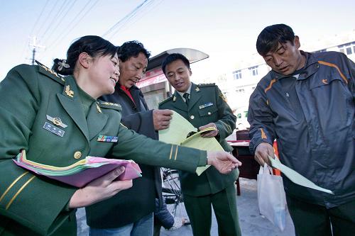 11月23日,武警西藏总队的干部为群众发放法制知识宣传单。当日,武警西藏总队退伍老兵在临别拉萨之前开展“为军旗添彩,为第二故乡做贡献”活动,老兵们充分利用在部队学到的一技之长,走上拉萨市大街小巷,为各族群众进行法律宣讲、种养殖技术培训、理发、修理自行车、送医送药等义务活动,受到各族群众的欢迎。新华社记者 张权 摄