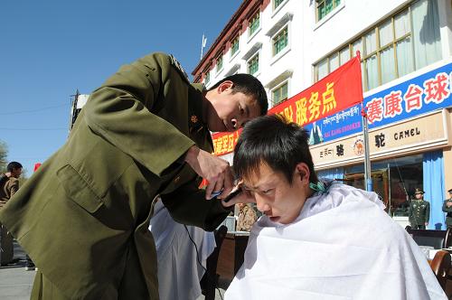 11月23日,驻藏某部在拉萨街头为群众义务理发。新华社记者 胡星 摄