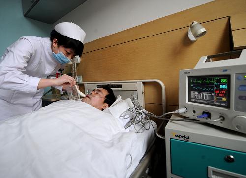 2月23日,在山西省人民医院,一名护士正在护理受伤的矿工张庆高。张庆高目前已暂时脱离生命危险。新华社记者 燕雁 摄