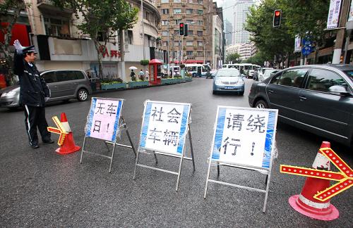 9月22日,一名上海交警正在限行路段指挥社会车辆绕行。为配合无车日活动,上海特地划定南京西路石门二路至华山路段作为无汽车示范区,从22日8时至22时半除公交车、出租车及特种车辆外,其它机动车一律不准驶入。当日是第三个“中国城市无车日”,今年“无车日”的主题是“健康环保的步行和自行车交通”,全国各地开展了自行车巡游、主题展板宣传、市民签名等多种形式的活动宣传绿色出行。新华社记者 裴鑫 摄