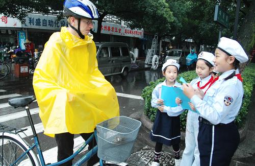 9月22日,苏州市“小交警”志愿者向一位骑自行车的外国友人发放“绿色出行”倡议书。当天是“无车日”,全国各地群众积极行动,倡导步行、骑自行车、乘公交车等方式绿色出行。新华社发(朱桂根 摄)